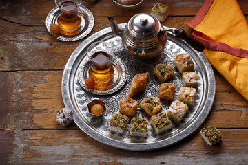 Obraz na płótnie Canvas Oriental sweets and turkish tea on a copper plate, copy space