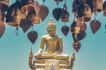 Golden Buddha next to the Big Buddha in Phuket, Thailand. Toned image with a vintage effect look. - obrazy, fototapety, plakaty