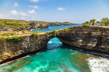 Fototapeta na wymiar Beautiful landscape of a Broken Beach, located in Nusa Penida Island, the southeast island of Bali, Indonesia. The amazing tourist attraction of the rock, cliff, mountain, and ocean waves.