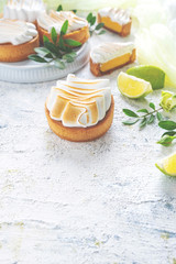Fresh lemon tartlets with meringue on white background,  close-up, copy space, wedding dessert, decorated.