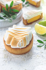 Obraz na płótnie Canvas Fresh lemon tartlets with meringue on white background, close-up, copy space, wedding dessert, decorated