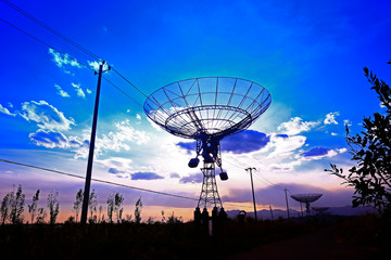 The silhouette of a radio telescope observatory