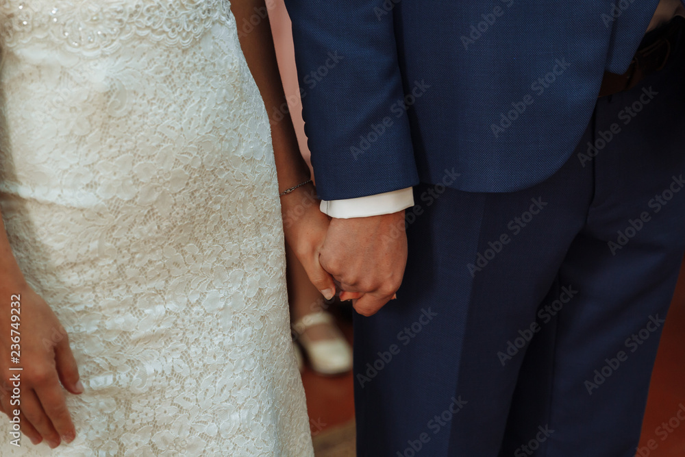 Wall mural newlyweds hold each other's hands with golden rings