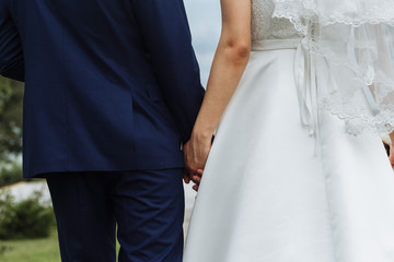 newlyweds hold each other's hands with golden rings