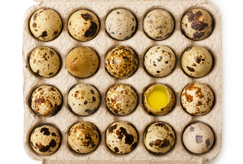 Quail eggs with one broken in cardboard