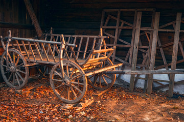 Fototapeta na wymiar old wooden empty cart at the farm in autumn