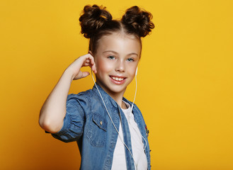 smiling little girl in casual clothes over yellow background