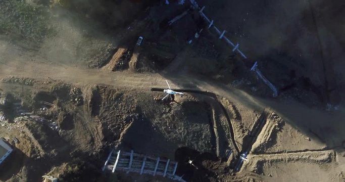 Aerial view helicopter flying over construction area. Helicopter working on industrial area for help construction building and transportation. Air transportation and industrial aviation concept
