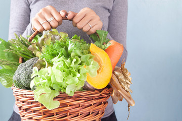 Woman's hands holding vegetables basket, Christmas or New Year gift set. Healthy concept
