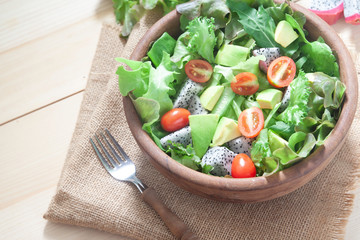 Fresh salad with avocado in wooden bowl. Healthy lifestyle concept