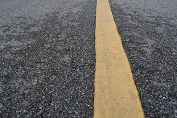 wet asphalt road with yellow line that using for separate lane roads.