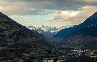 Fototapeta na wymiar Bonito pueblo de montaña ubicado en un valle frente a montañas nevadas