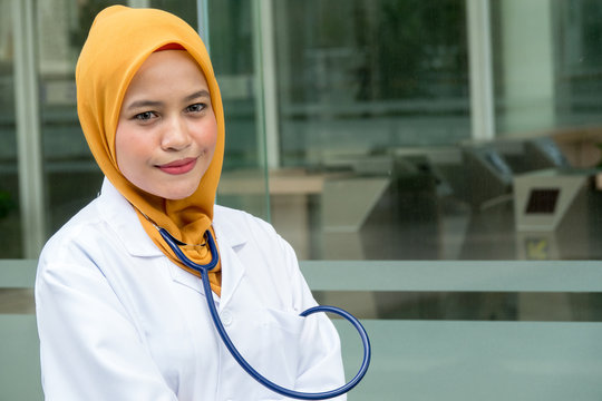 Confident female doctor standing infront of  office and smiling at camera, health care and prevention concept