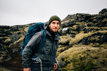 Smiling and happy portrait of young handsome traveller or hiker enjoying the outdoors activity....