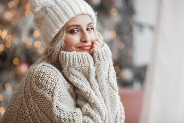 Close up portrait of young beautiful woman on Christmas background. Smiling girl with perfect skin...