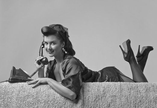 Beautiful woman speaking via vintage phone.