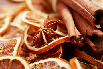 dry citrus fruits, cinnamon sticks and anise on wooden background