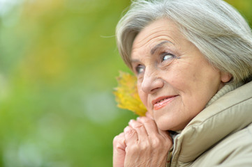 Portrait of happy senior beautiful woman in autumnal park