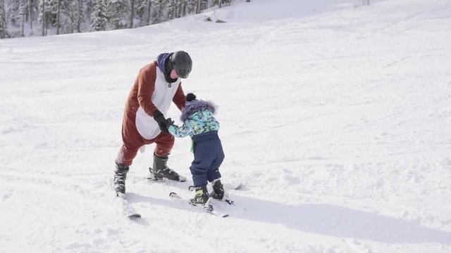 The child learns to ski with an instructor. Ski resort. Active sport