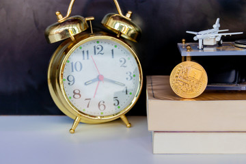 bitcoin coins on book alarm clock old gold and model of passenger plane over white black background with copy space add text. color vintage style tone