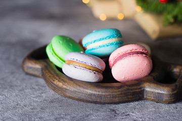 Delicious christmas dessert with festive decoration. Cake macaron or macaroon on gray background from above. Colorful almond cookies, bright colors.