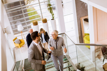 Businessmen and businesswomen walking and taking stairs in an office building