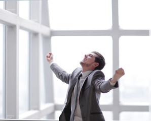 triumphant businessman standing in the office.photo with copy space