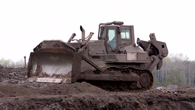 A large bulldozer pushes waste at a landfill. Waste metal from the factory.