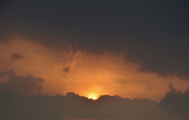 sun down behind big gray cloud in evening