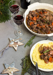 Beef bourguignon or meat stew with vegetables and herbs in a casserole.
