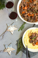 Beef bourguignon or meat stew with vegetables and herbs in a casserole.