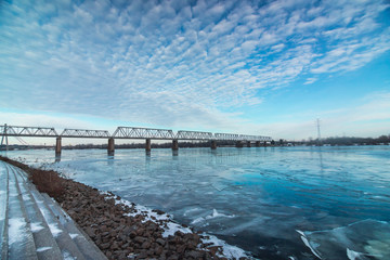 Obraz premium Railway bridge across Dnipro with beautiful cloudy sky in Kyiv, Ukraine