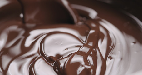closeup stirring melted dark chocolate with spoon