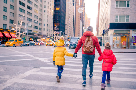 Family Of Father And Little Kids On Times Square During Their Vacation In New York City