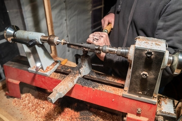 Handwerker schleift Holz an Drehbank