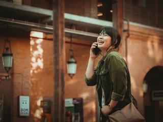 Asian woman using smartphone with happy mood in shopping mall