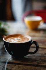 Black cup with coffee with beautiful latte art