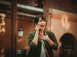 Fototapeta premium Asian woman using smartphone with happy mood in shopping mall