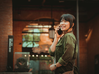 Fototapeta premium Asian woman using smartphone with happy mood in shopping mall