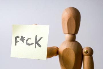 Concept Bad mood. Problems in life. Agressive angry wood mannequin doing Screw You fuck sign with middle finger on white background