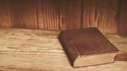 Old book on wooden shelf