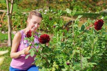 Young Beautiful European lady is handling her flowers in the countryside garden. © Artem