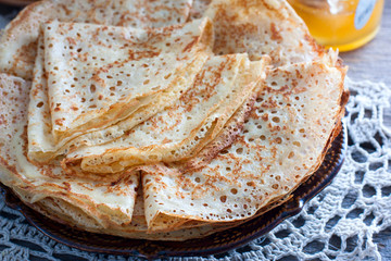 Fishnet thin pancakes on the table with a napkin, horizontal