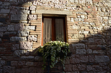 Fototapeta na wymiar Gubbio medievale. Architettura in pietra. italia, europa ed il fascino antico. Finestre tra le pietre