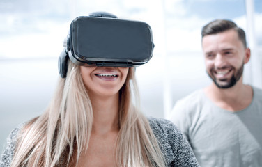 Girl in VR glasses of virtual reality with gamepad playing game