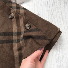 Female brown wool skirt close up on wooden background