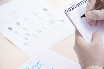 Forensic expert studying fingerprints in the lab
