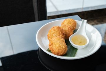 Fried shrimp cake, served on white dish in restaurant