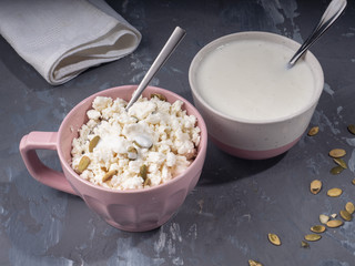 Light breakfast made of cottage cheese and sour cream in pink ceramic dishes
