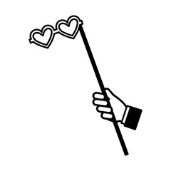 hand with glasses with heart shaped lens in stick